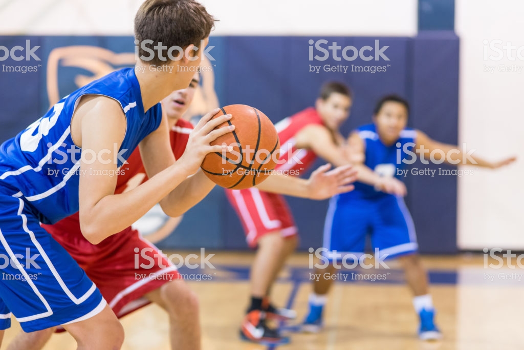 Boys high school basketball team: player about to shoot over defender
